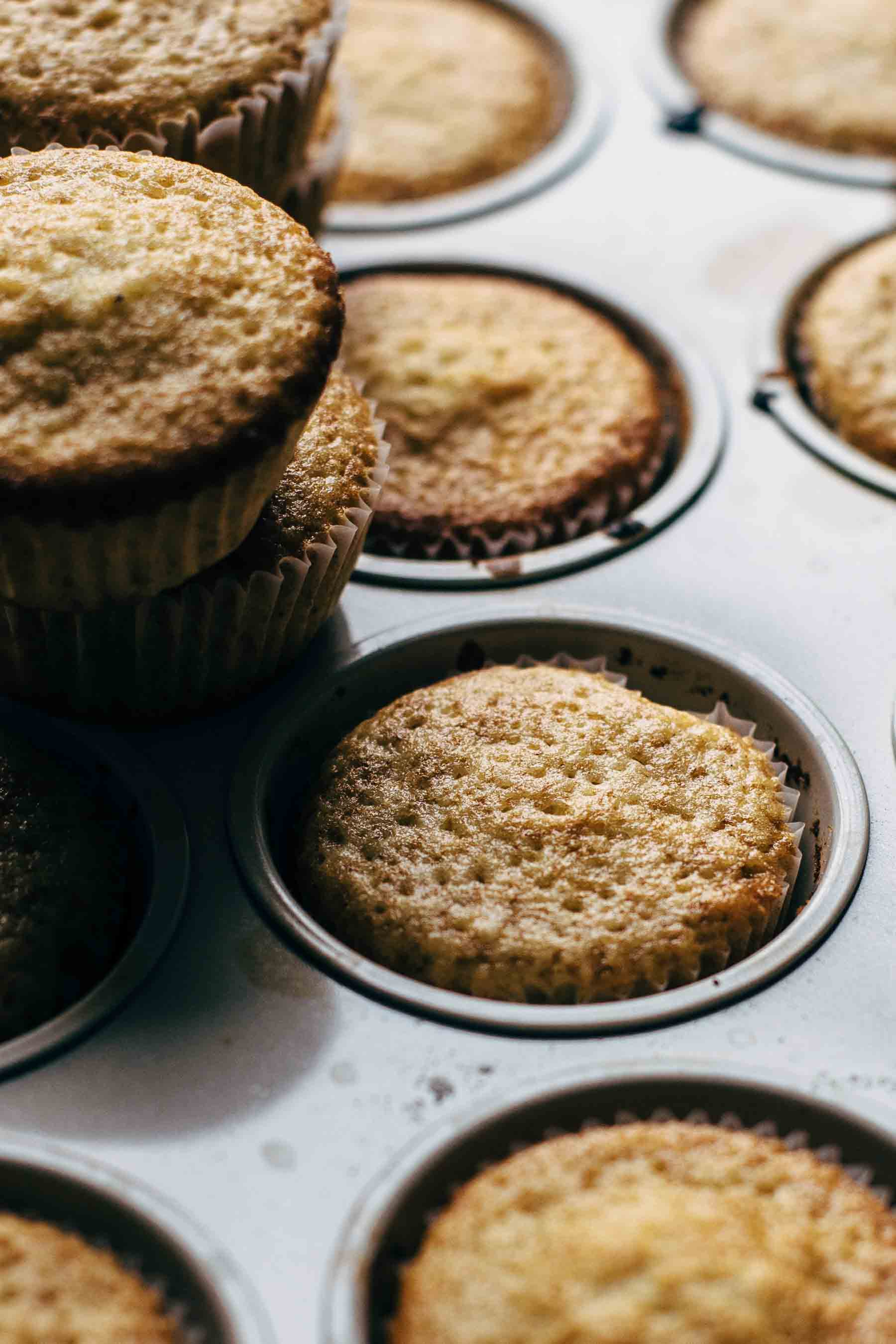A cupcake pan full with baked cupcakes