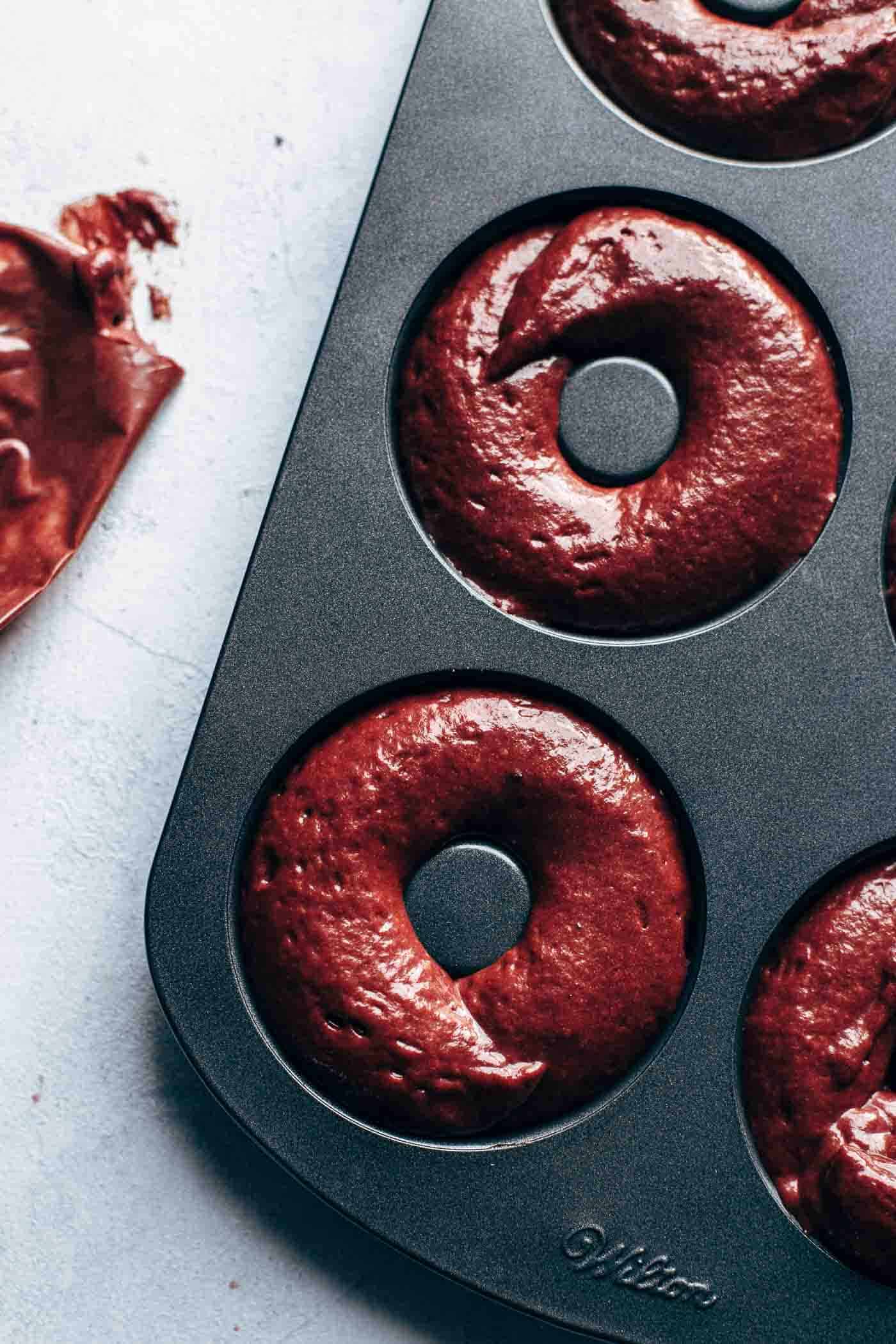 Donut pan filled with red velvet cake batter