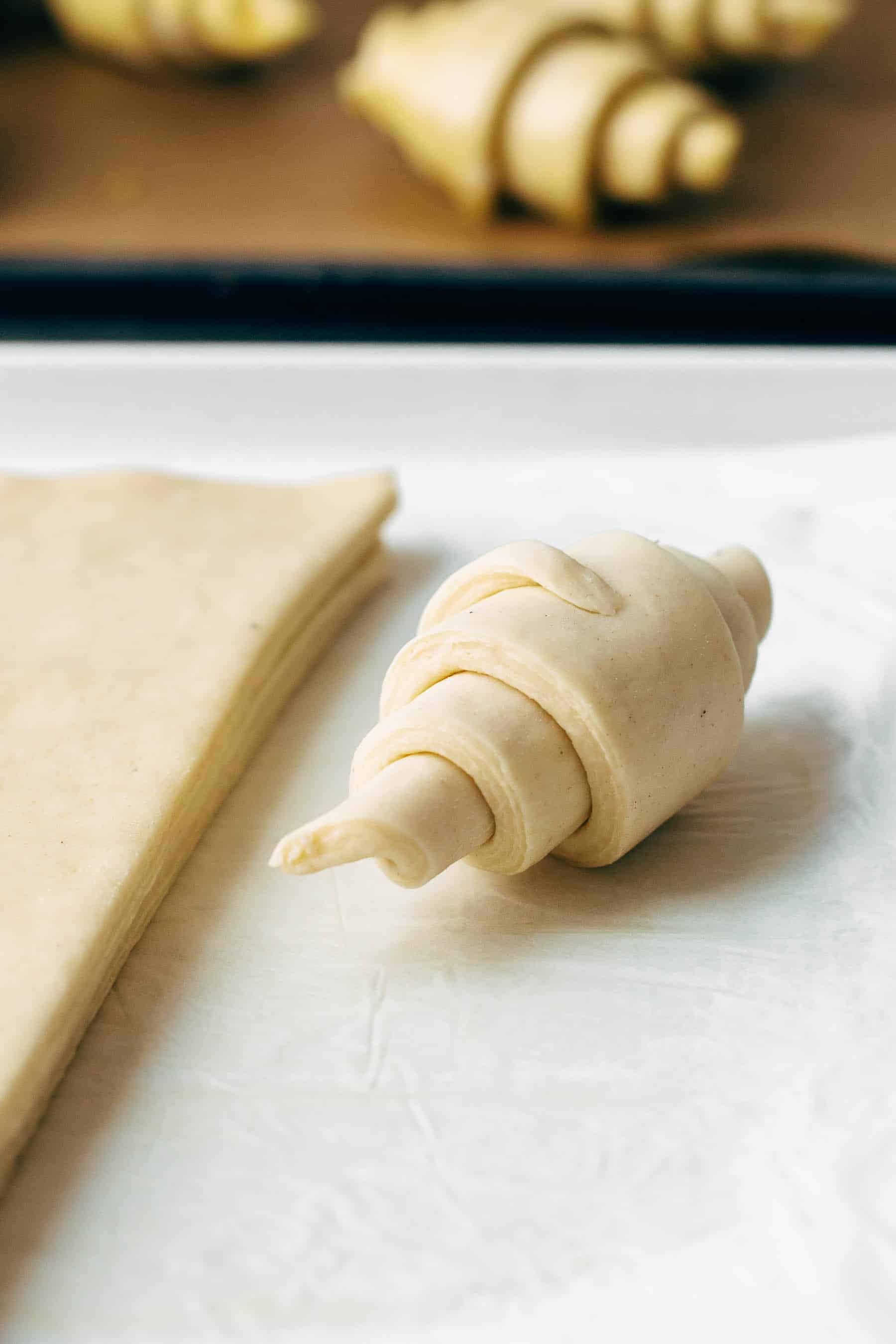 Close up of a rolled up unbaked croissant on a bright surface