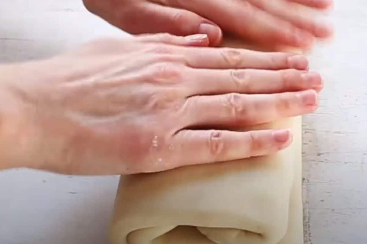 patting excess flour from croissant dough