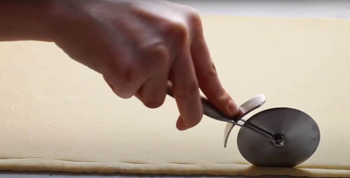 marking croissant dough with pizza cutter