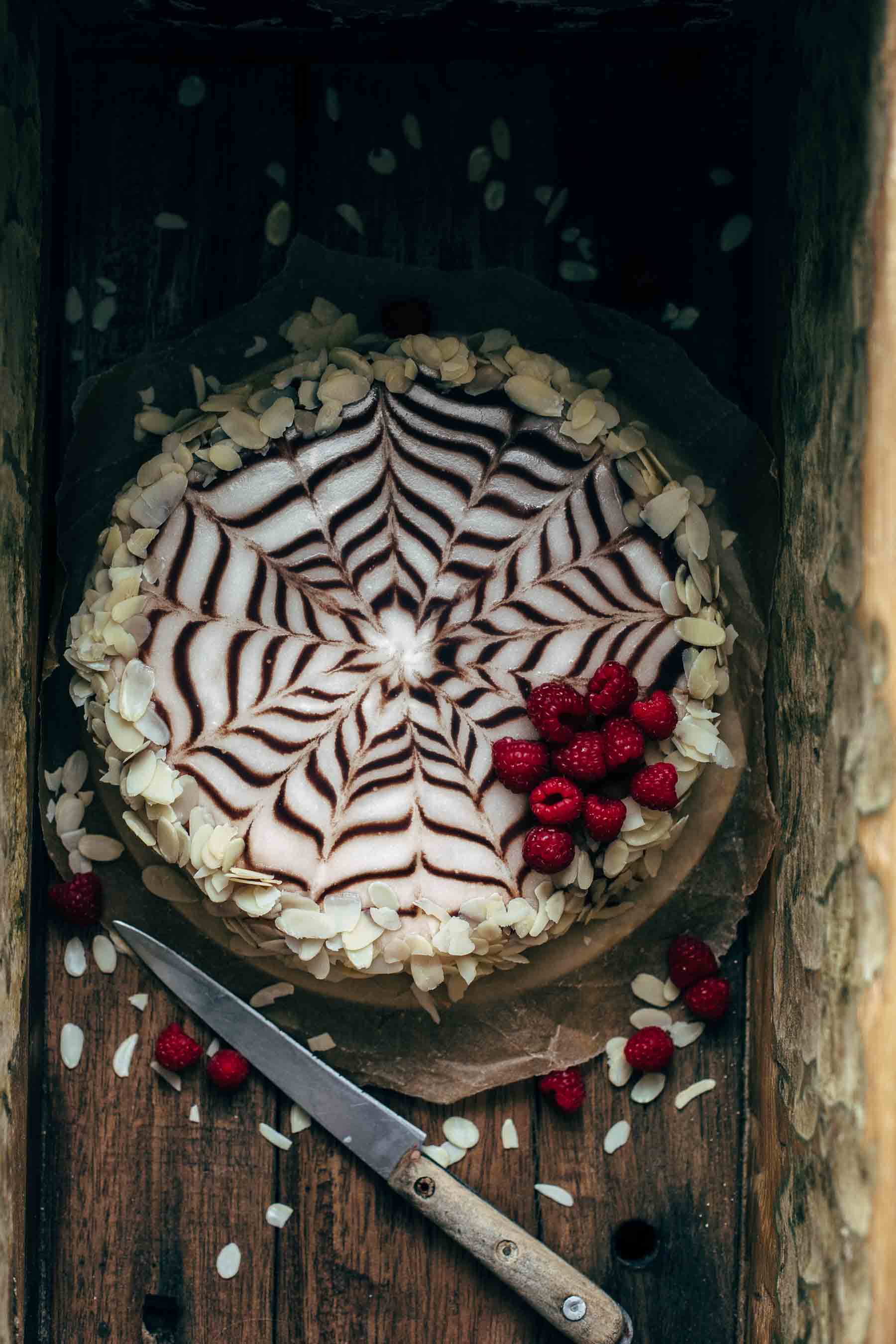 Esterhazy torte in a wooden box with raspberries and almond decoration
