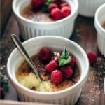 Half eaten custard in a ramekin with a spoon sticking in