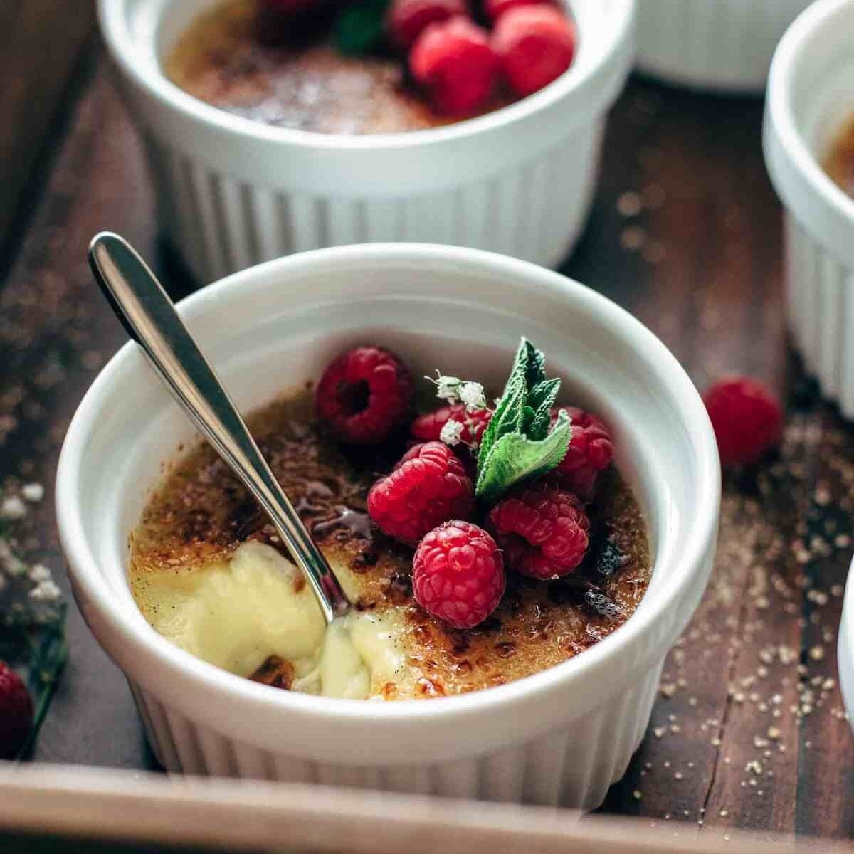Half eaten custard in a ramekin with a spoon sticking in