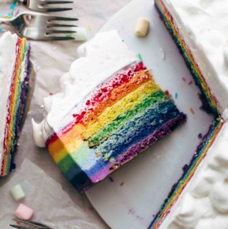 Sliced rainbow cake on a cake plate