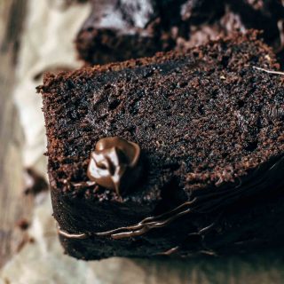 Slices of dark chocolate zucchini loaf with dollops of chocolate spread on top