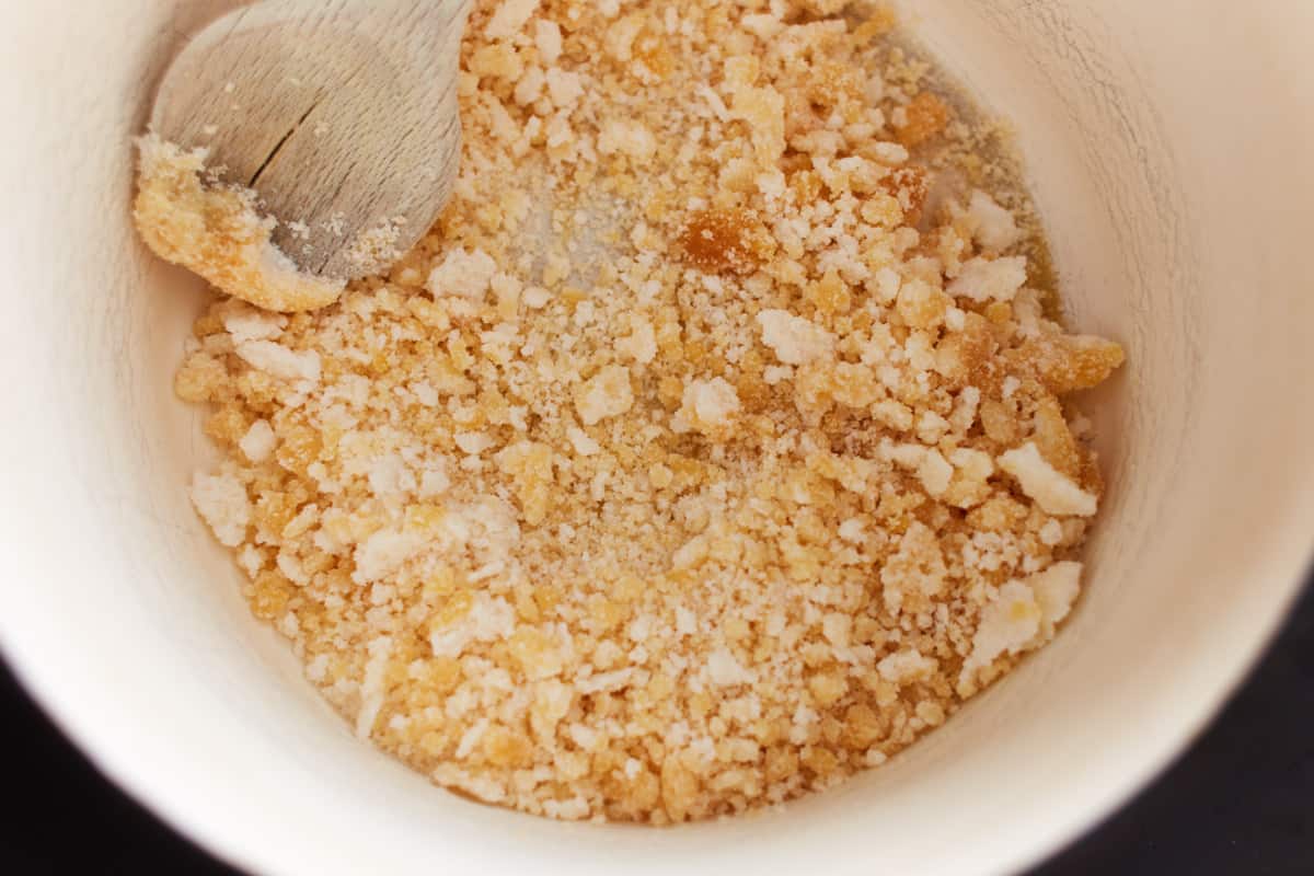 Crumbly sugar in a white pot with a wooden spoon