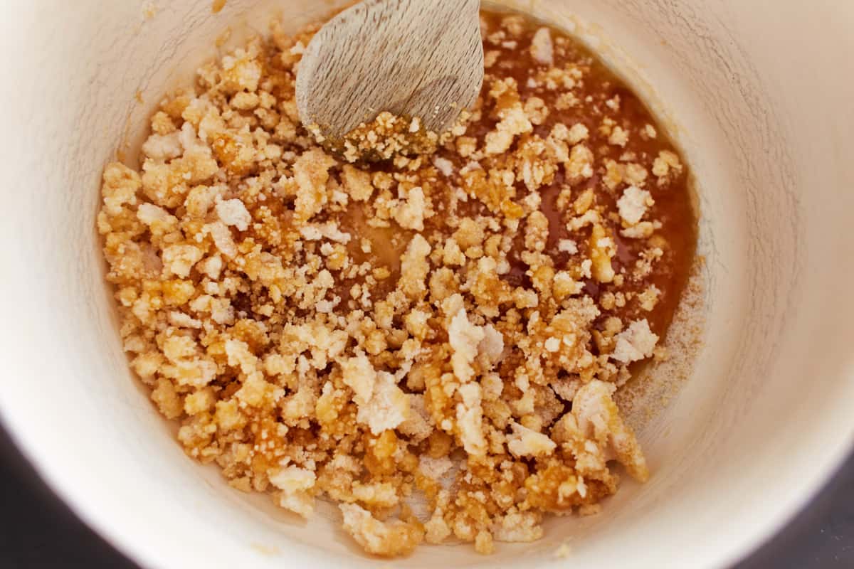 Cooking sugar in a pot with part of the sugar being crumbly and part liquid