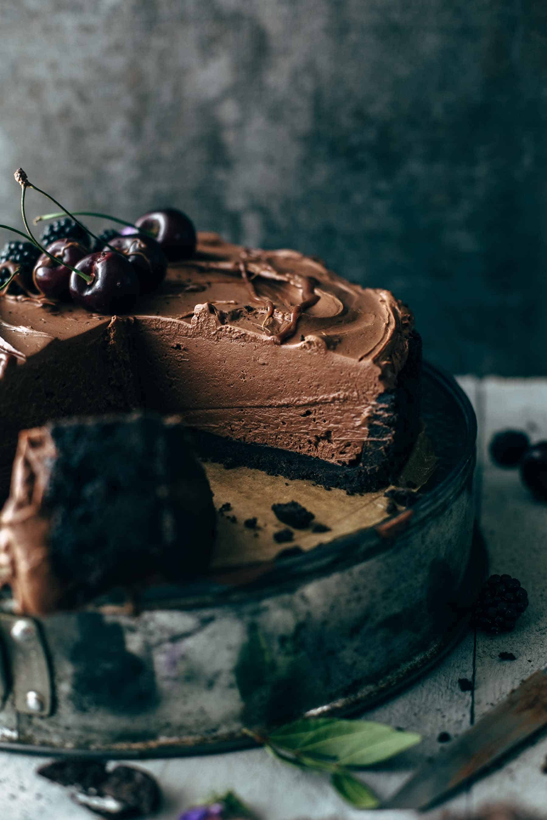 chocolate cheesecake sitting on an inverted springform pan with one third of the cake missing