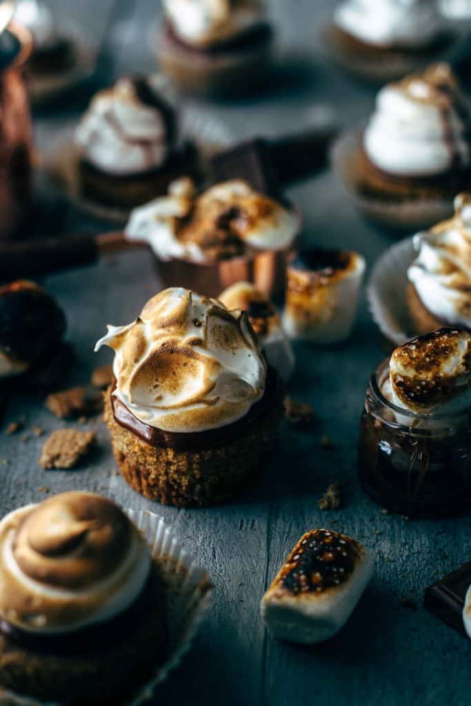 S'mores cupcakes with toasted marshmallows on a wooden board