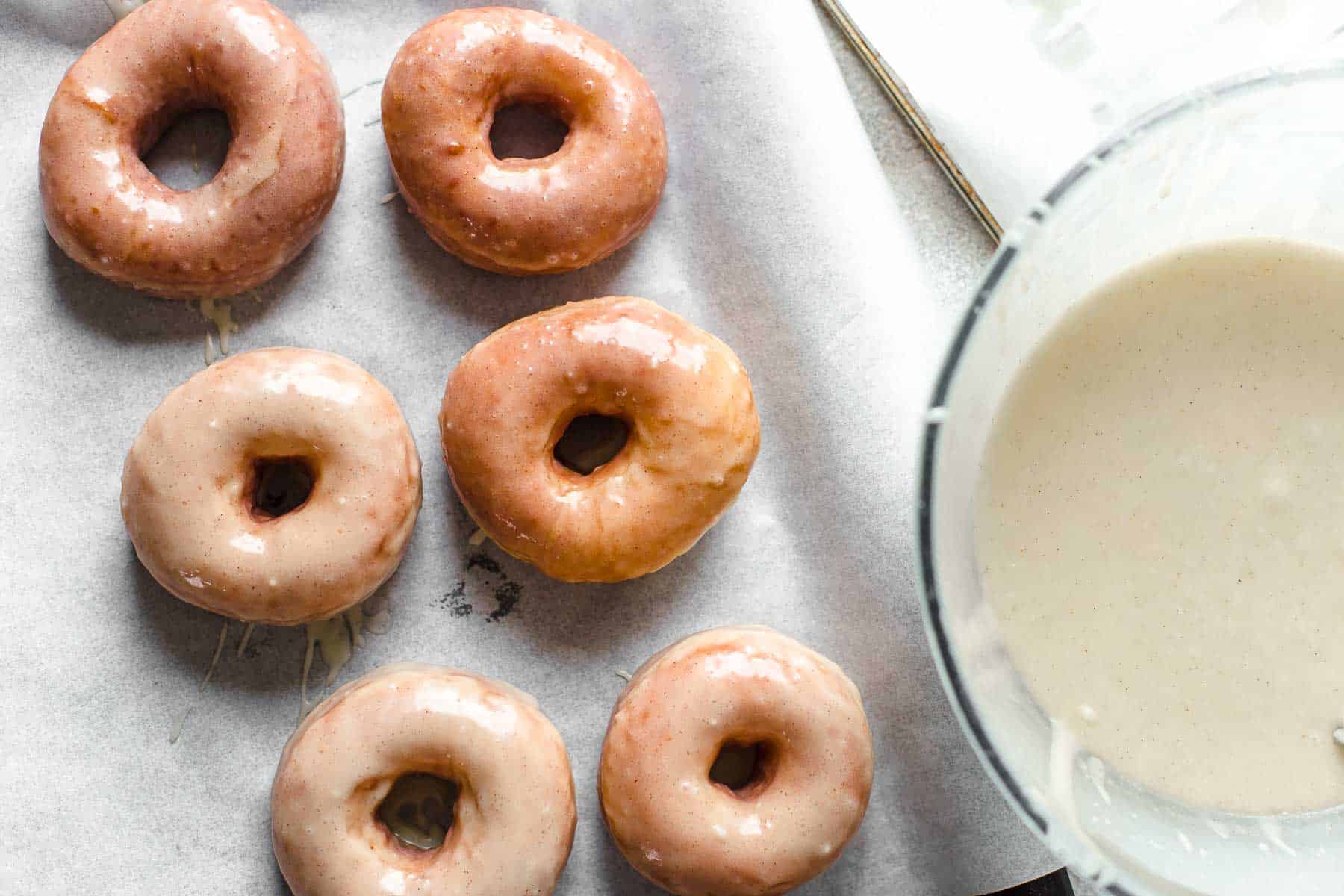 Freshly glazed doughnuts on baking sheet