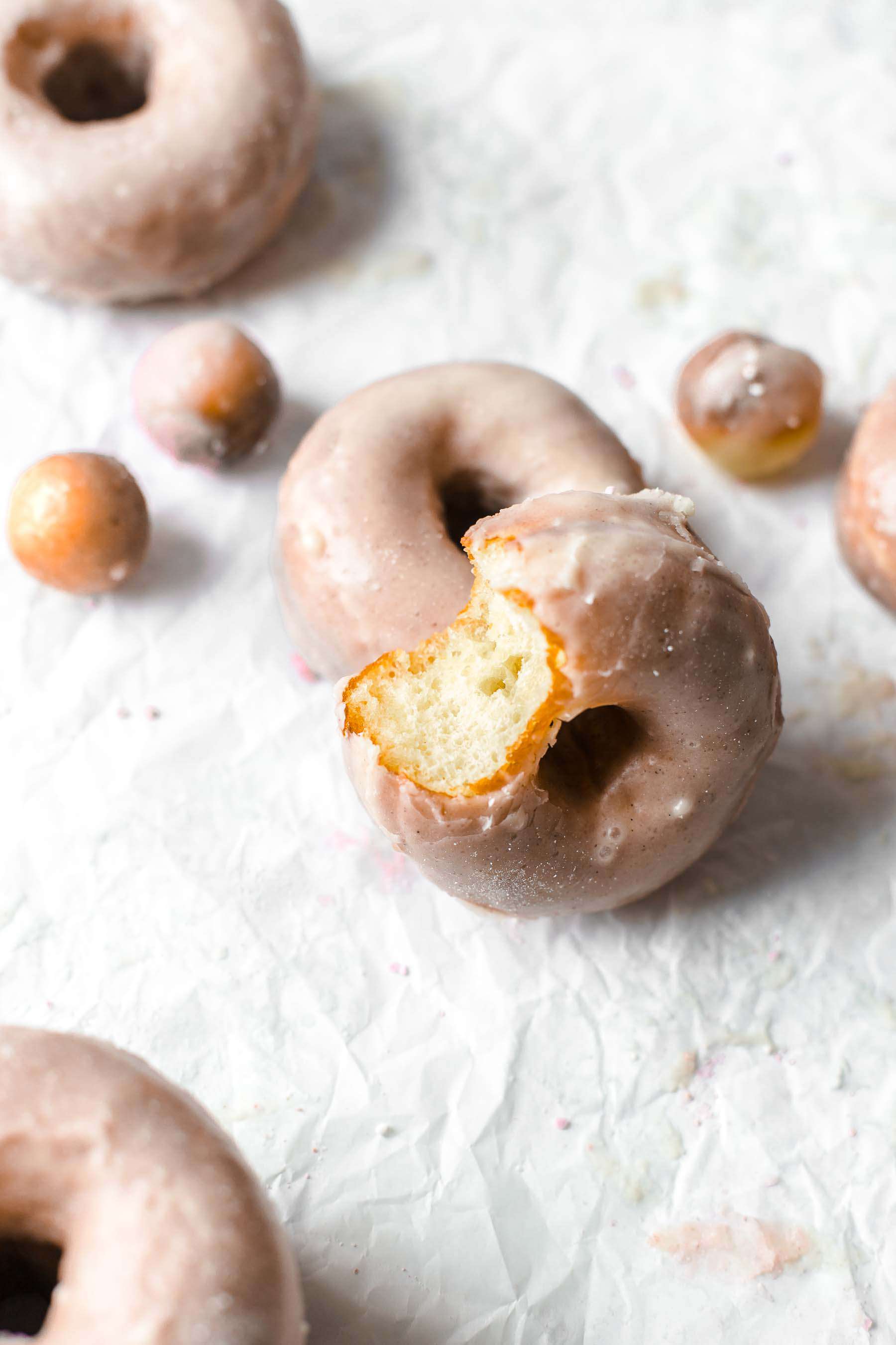 Bitten donut, donuts and donut holes on white background