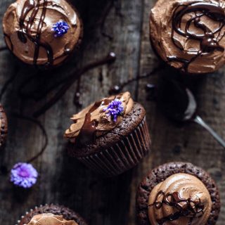 Brownie cupcakes with chocolate and flower decoration on a wooden board