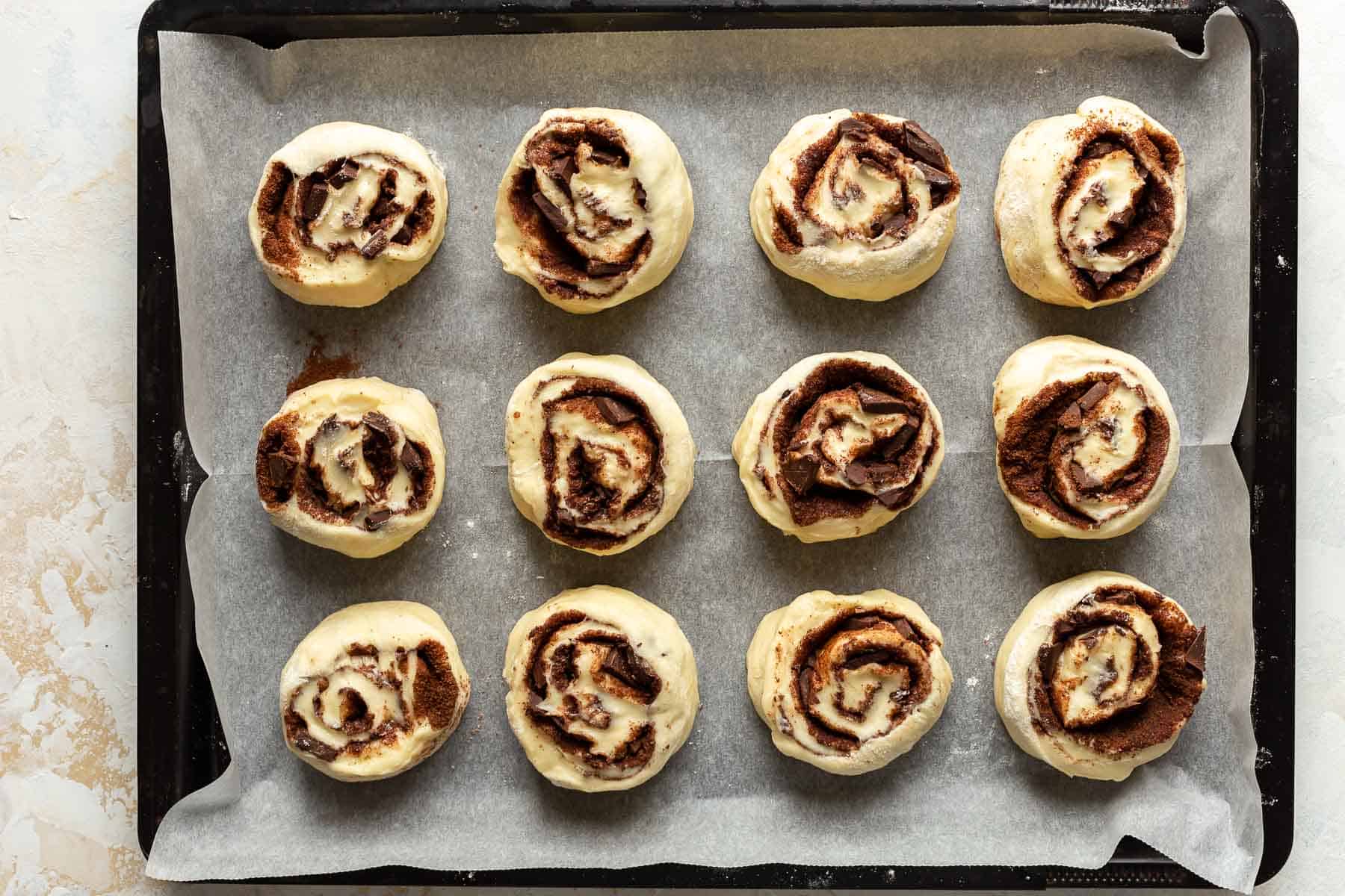 chocolate rolls dough rising in pan before baking