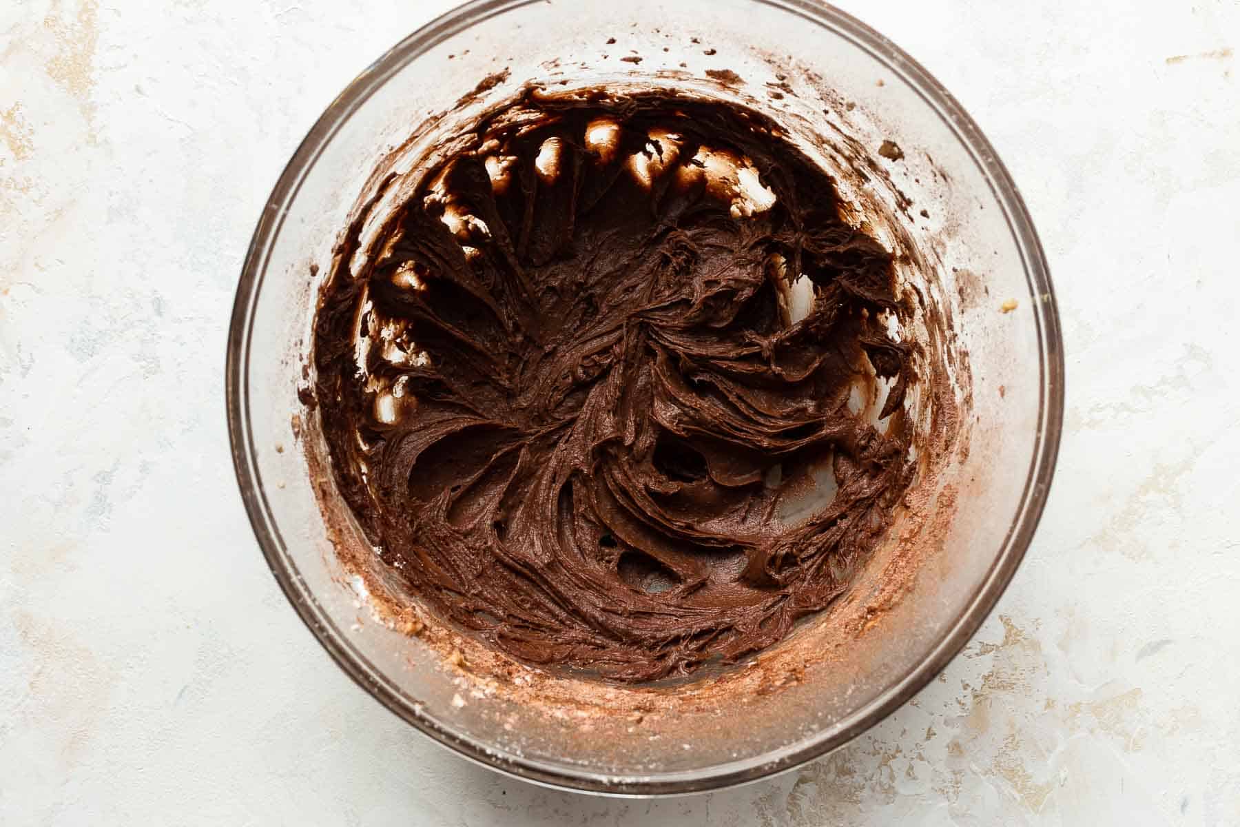 creamy chocolate frosting in bowl for cinnamon rolls