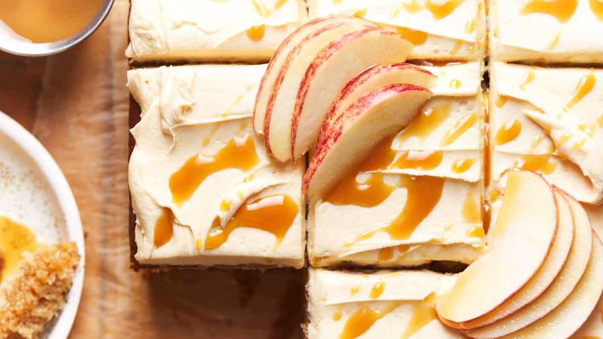 Slices of frosted apple cake topped with caramel sauce and apple slices