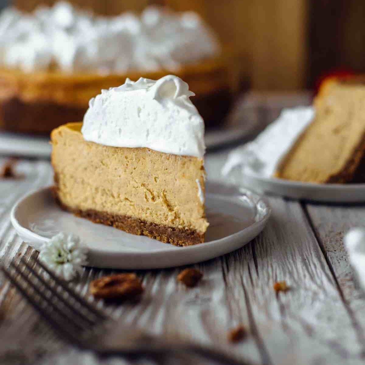 A slice of sweet potato cheesecake on a dessert plate topped with meringue
