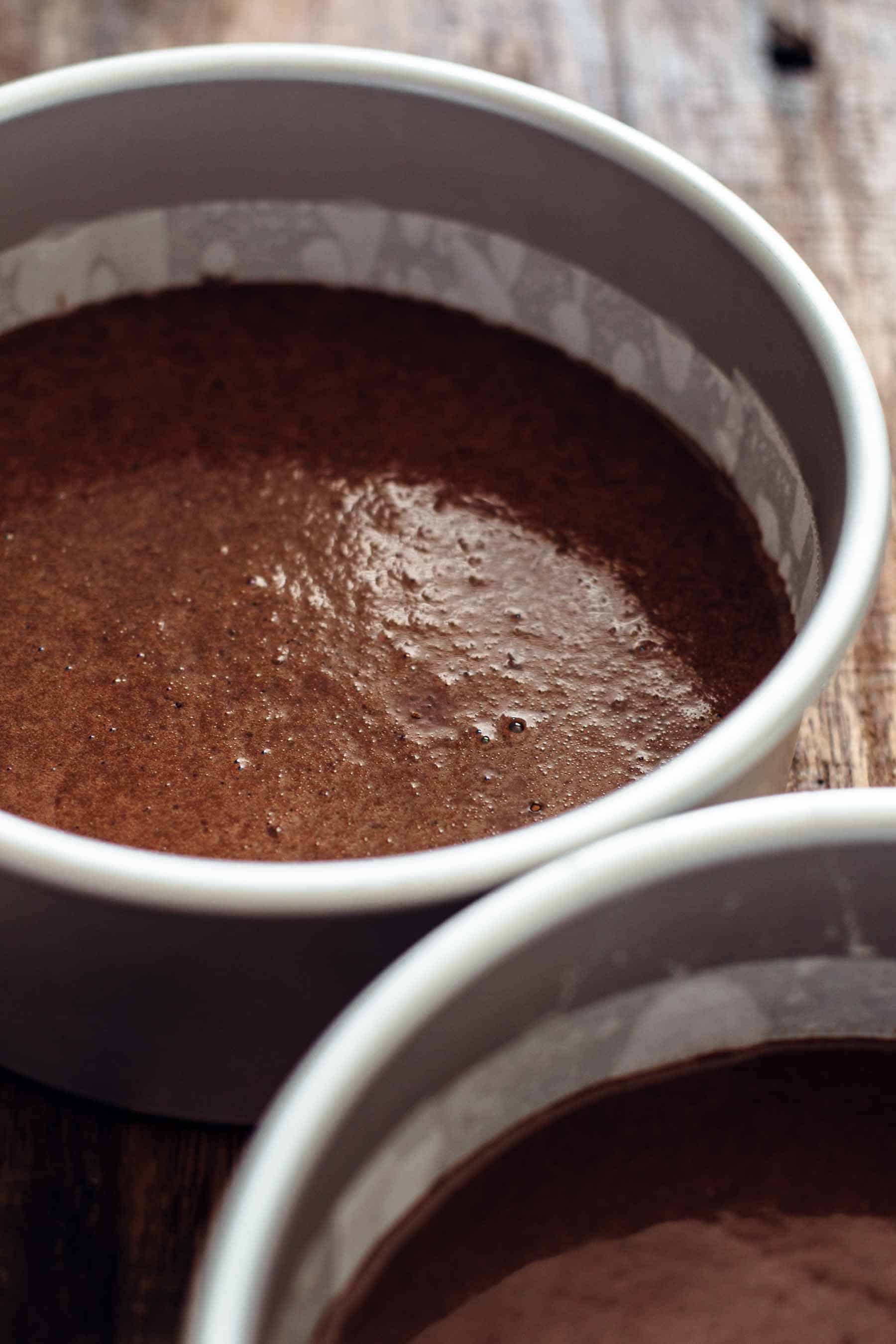 two cake pans filled with raw chocolate batter