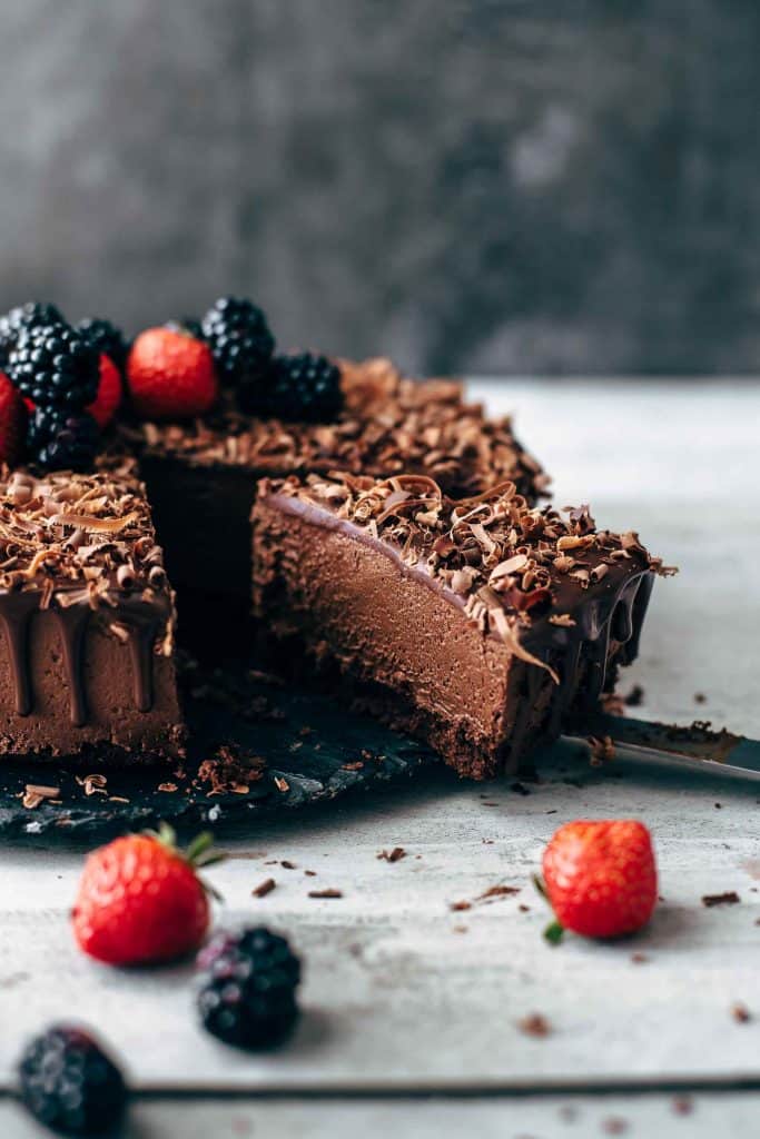 Cut chocolate cake on a black cake plate