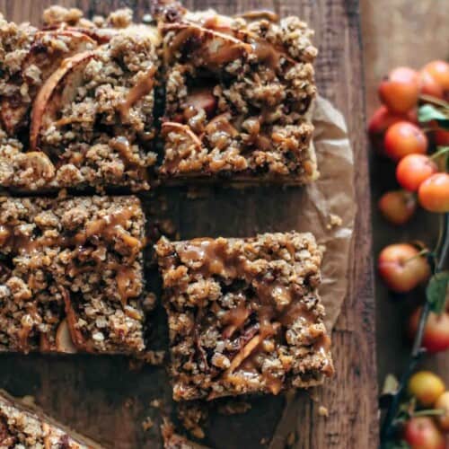 half dozen apple pecan bars on a wooden tray with caramel drizzle on top