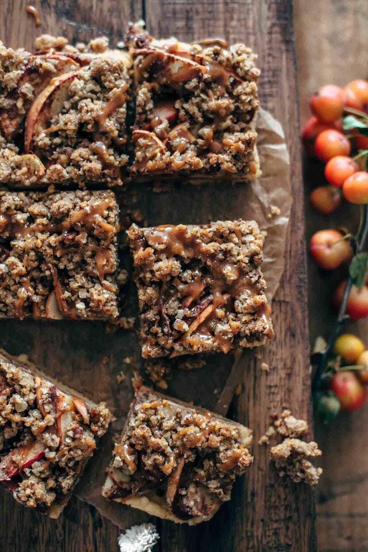 half dozen apple pecan bars on a wooden tray with caramel drizzle on top