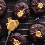 half dozen baked chocolate cookies filled with peanut butter on a wire rack