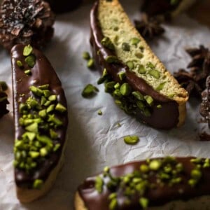 chocolate dipped and nut sprinkled biscotti on white paper