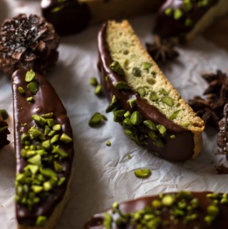 chocolate dipped and nut sprinkled biscotti on white paper