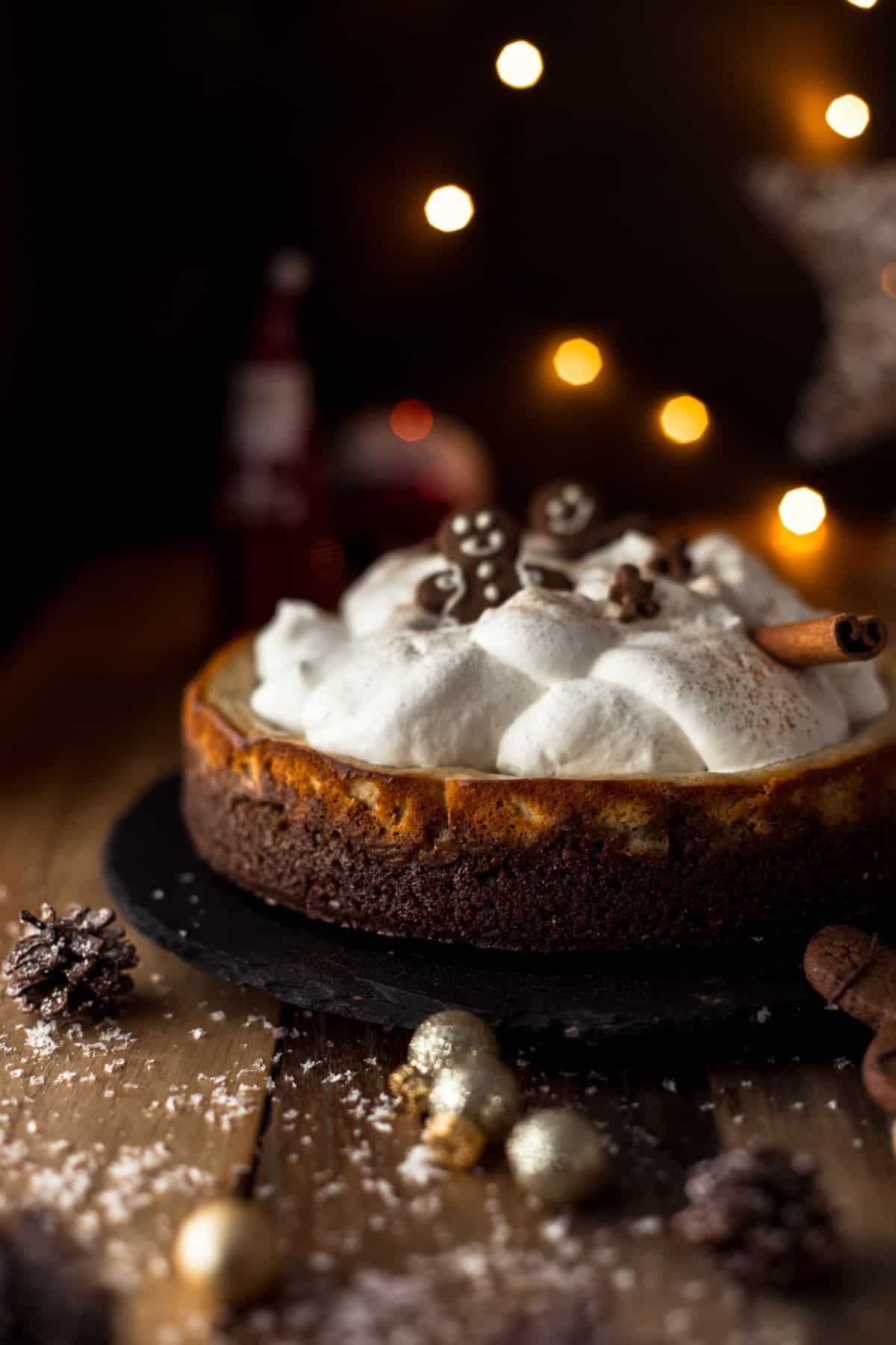 baked cheesecake topped with whipped cream and gingerbread men cookies