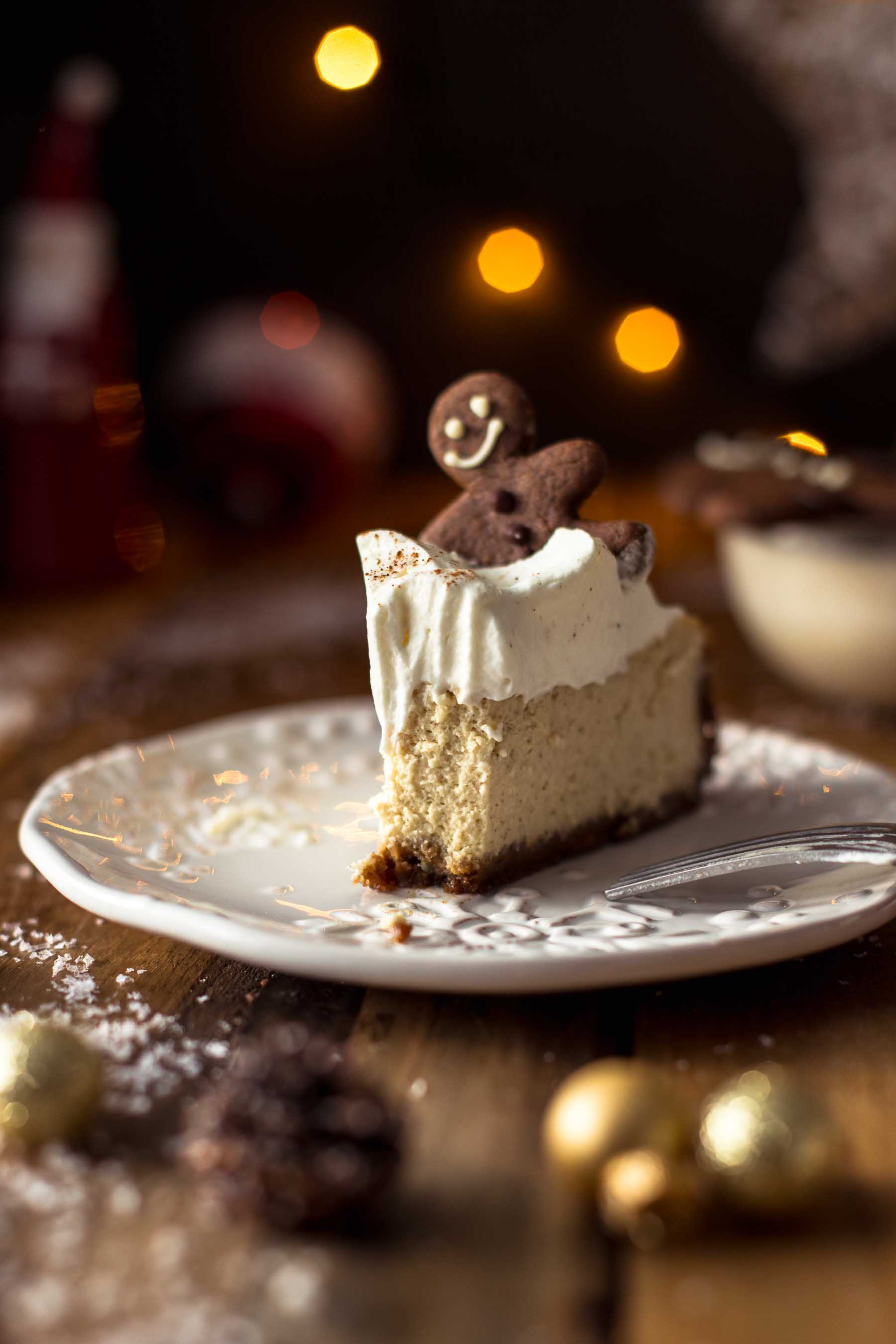 A slice of Baked Eggnog Cheesecake with Gingerbread Crust with a bite