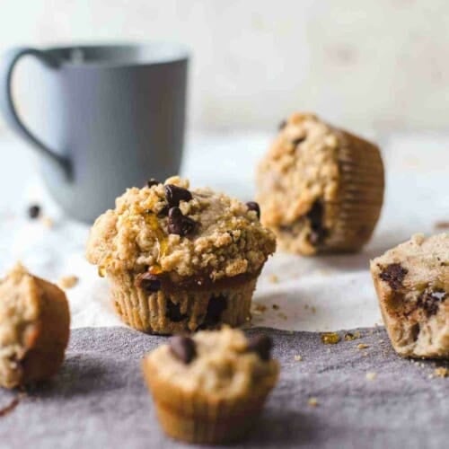regular and mini sized muffins on a two colored napkin with a blue colored cup