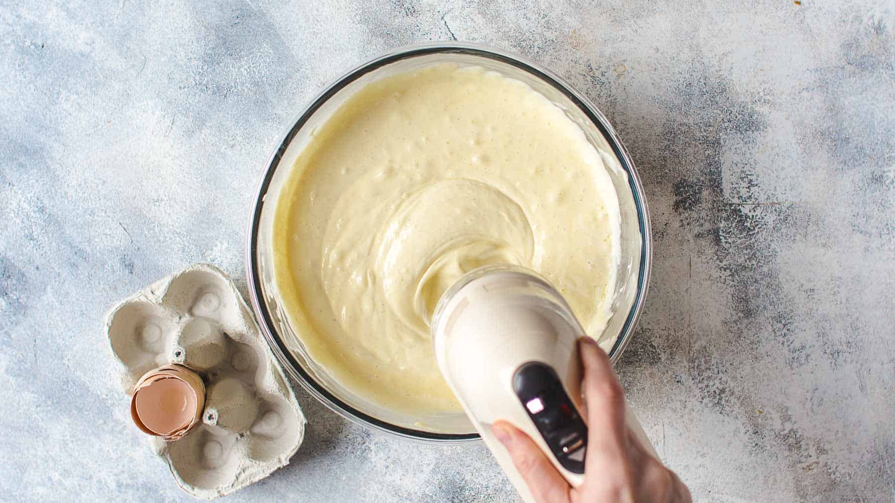 mixing cheesecake batter in a bowl