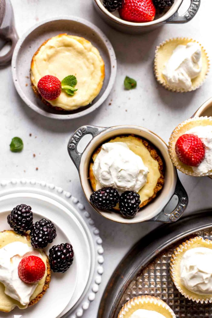 mini cheesecakes decorated with berries and whipped cream