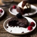 half eaten lava cake with gooey chocolate center oozing out of the center on a plate