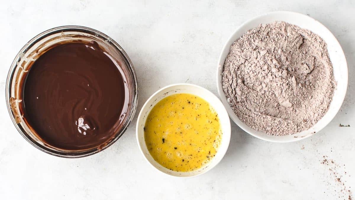 Three bowls with ingredients for mini chocolate cakes