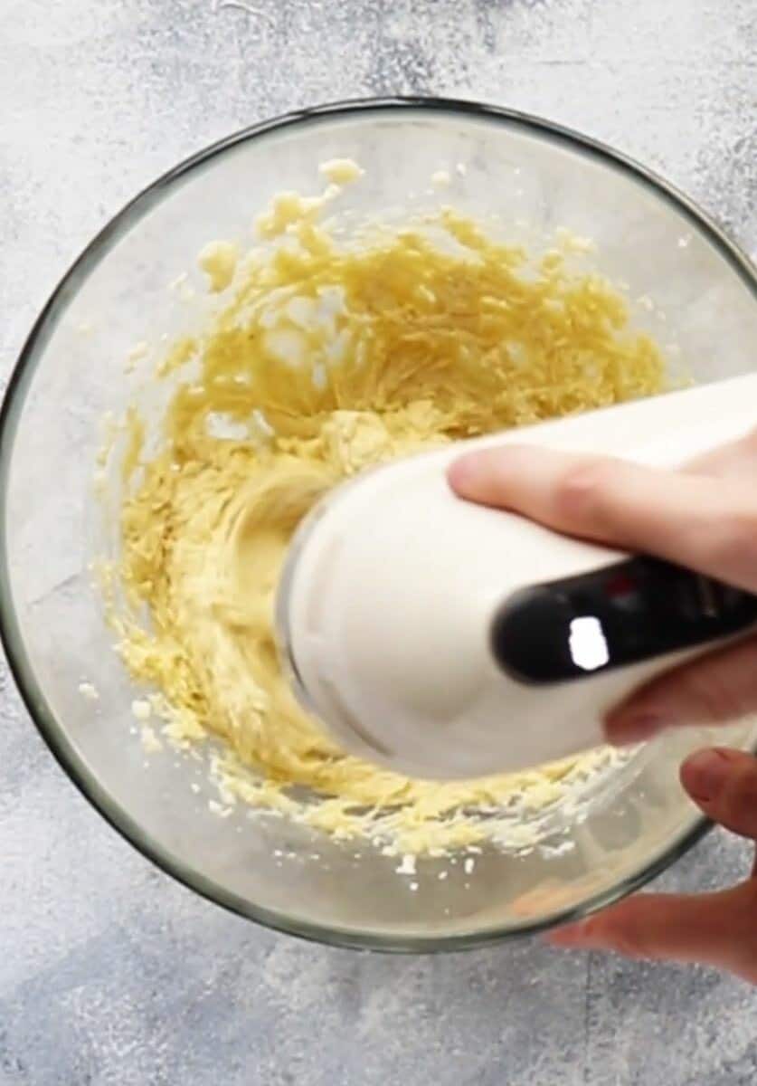 beating butter, egg and vanilla in a glass bowl