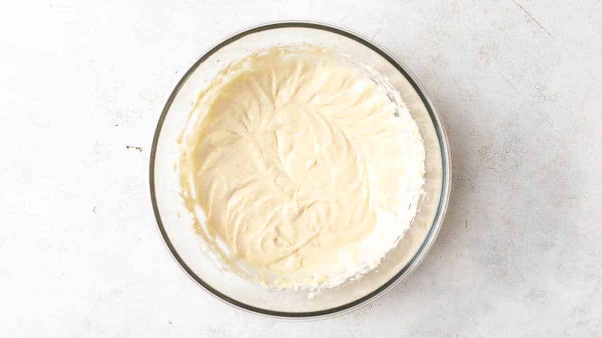 beaten cream cheese in a glass bowl