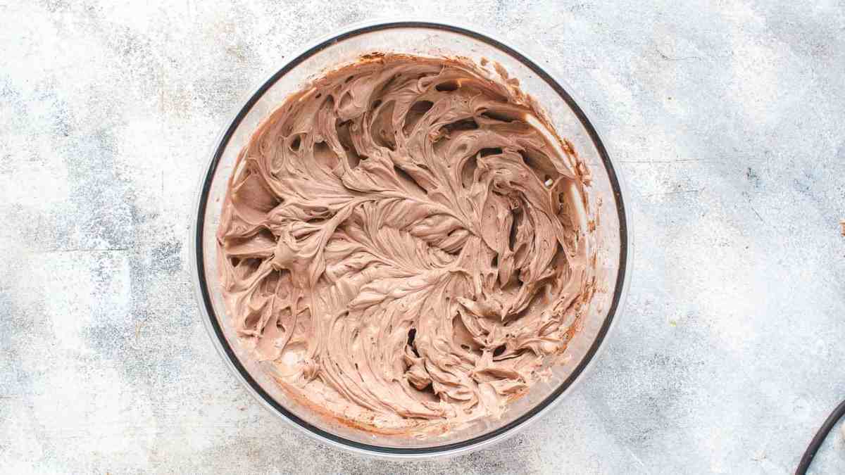 cocoa, sugar, and cream cheese mixed together in a mixing bowl