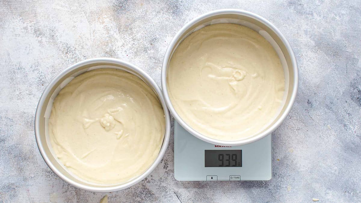 Lemon cake batter in cake pans on kitchen scale