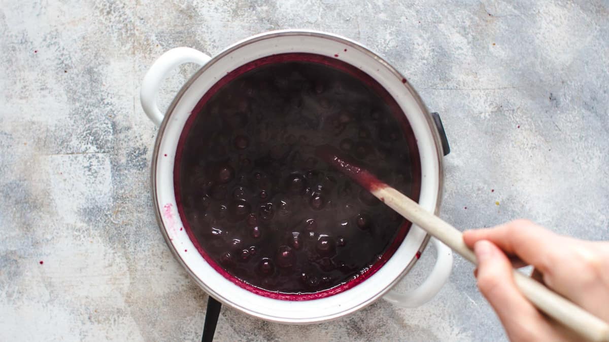 Cooking blueberry filling in pot over heat