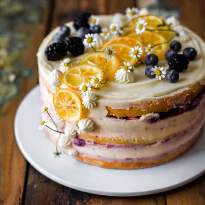 Decorated lemon blueberry layer cake on a white cake plate