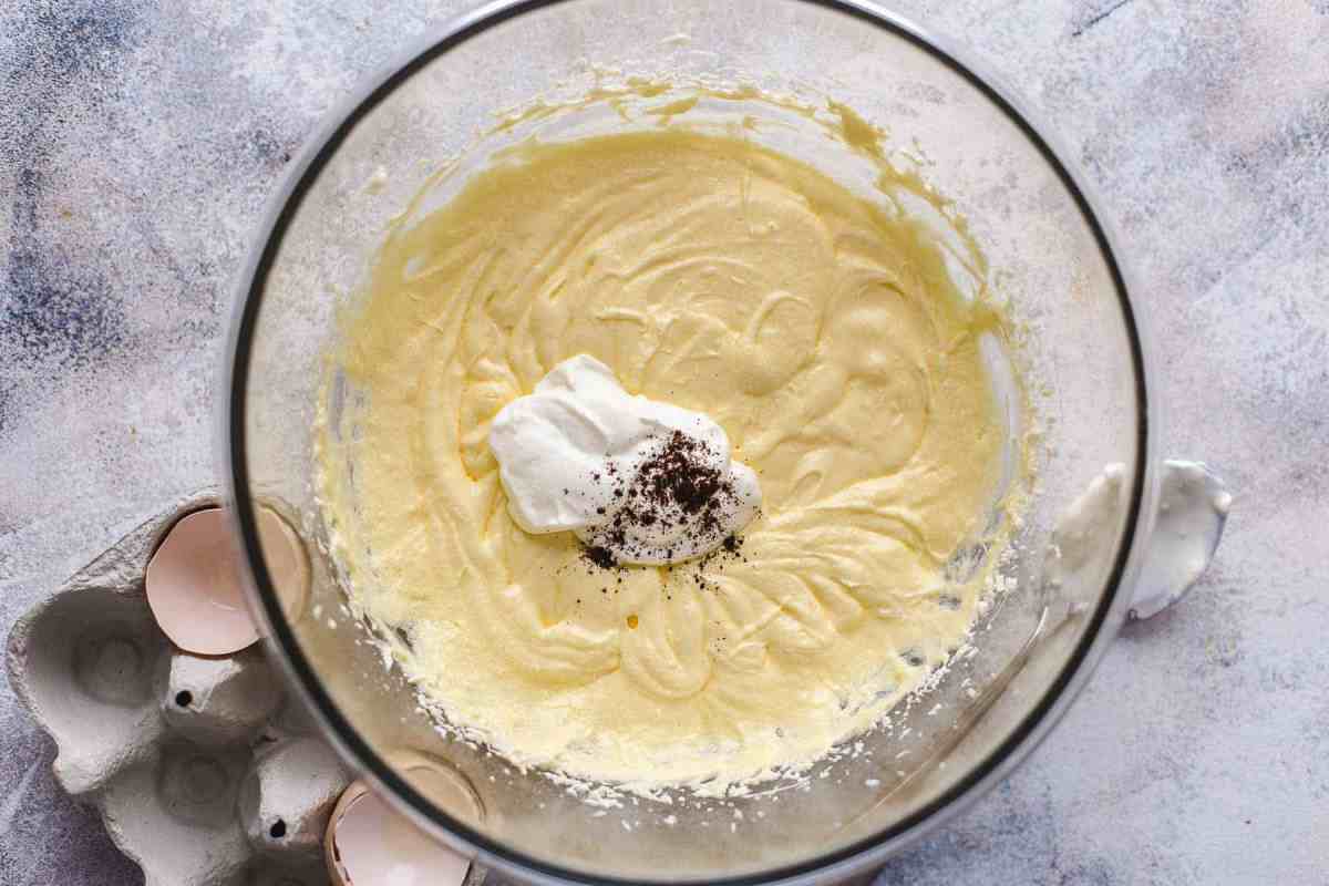 Mixing progress: adding sour cream and vanilla to the pistachio cake batter