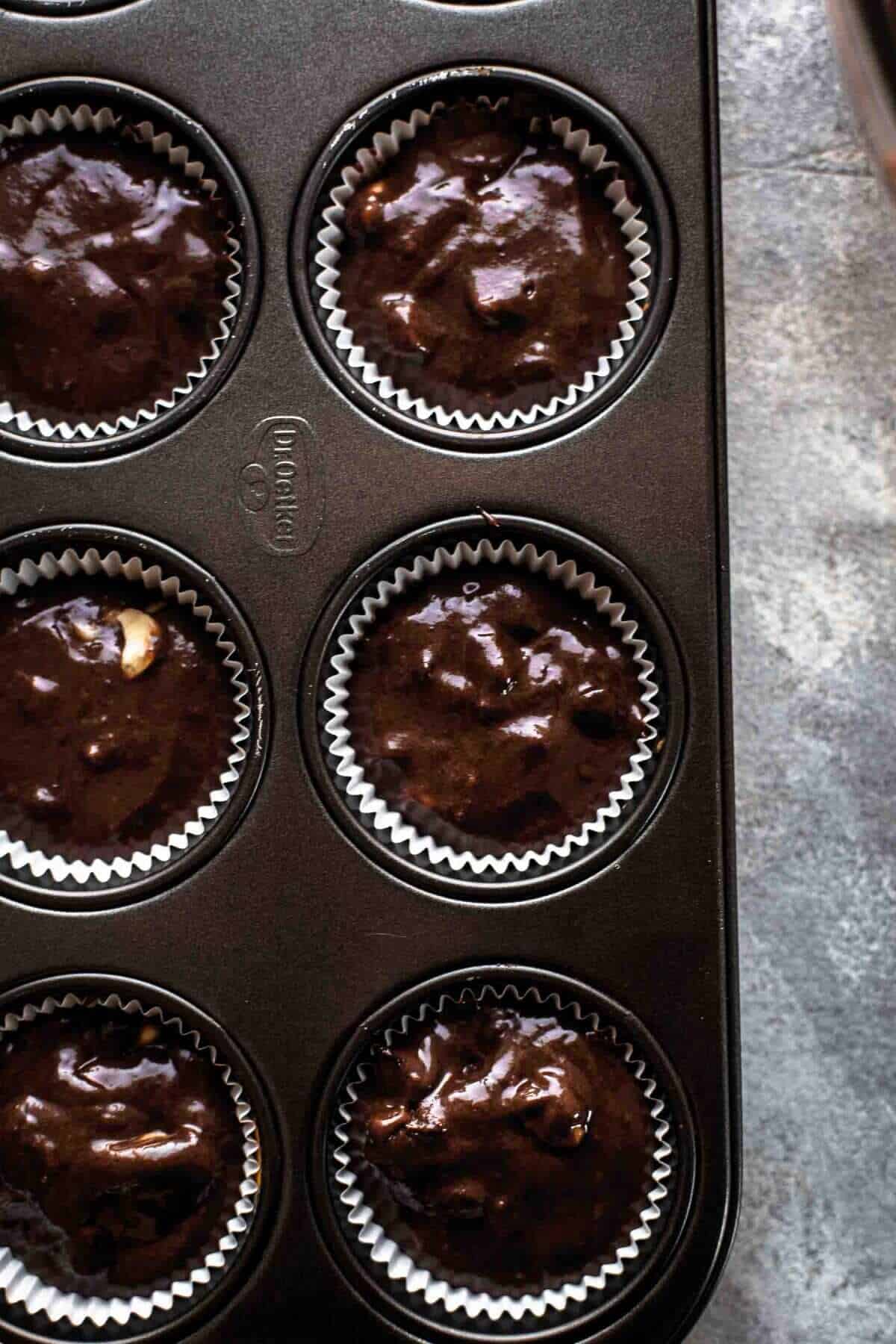 Filled muffin liners with chocolate banana muffins batter