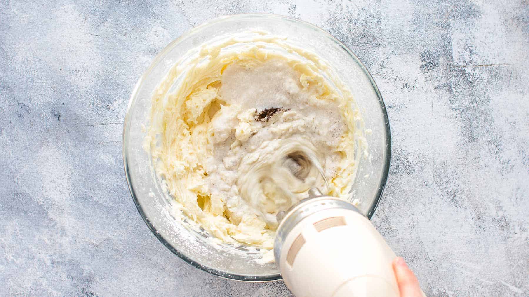 Adding coconut milk and vanilla to the frosting