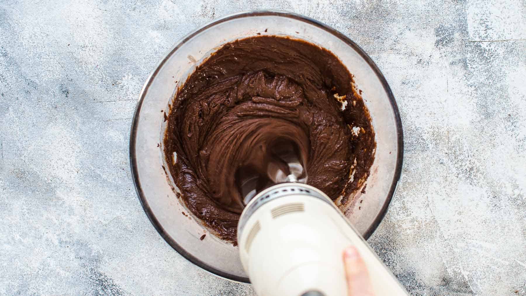 mixing thick chocolate cake batter in a mixing bowl
