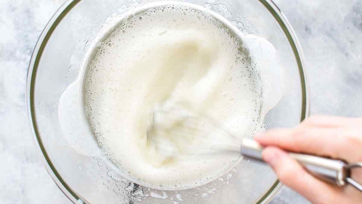 whisking egg whites, sugar, and cream of tartar for 2 minutes in a bowl over a pot of boiling water