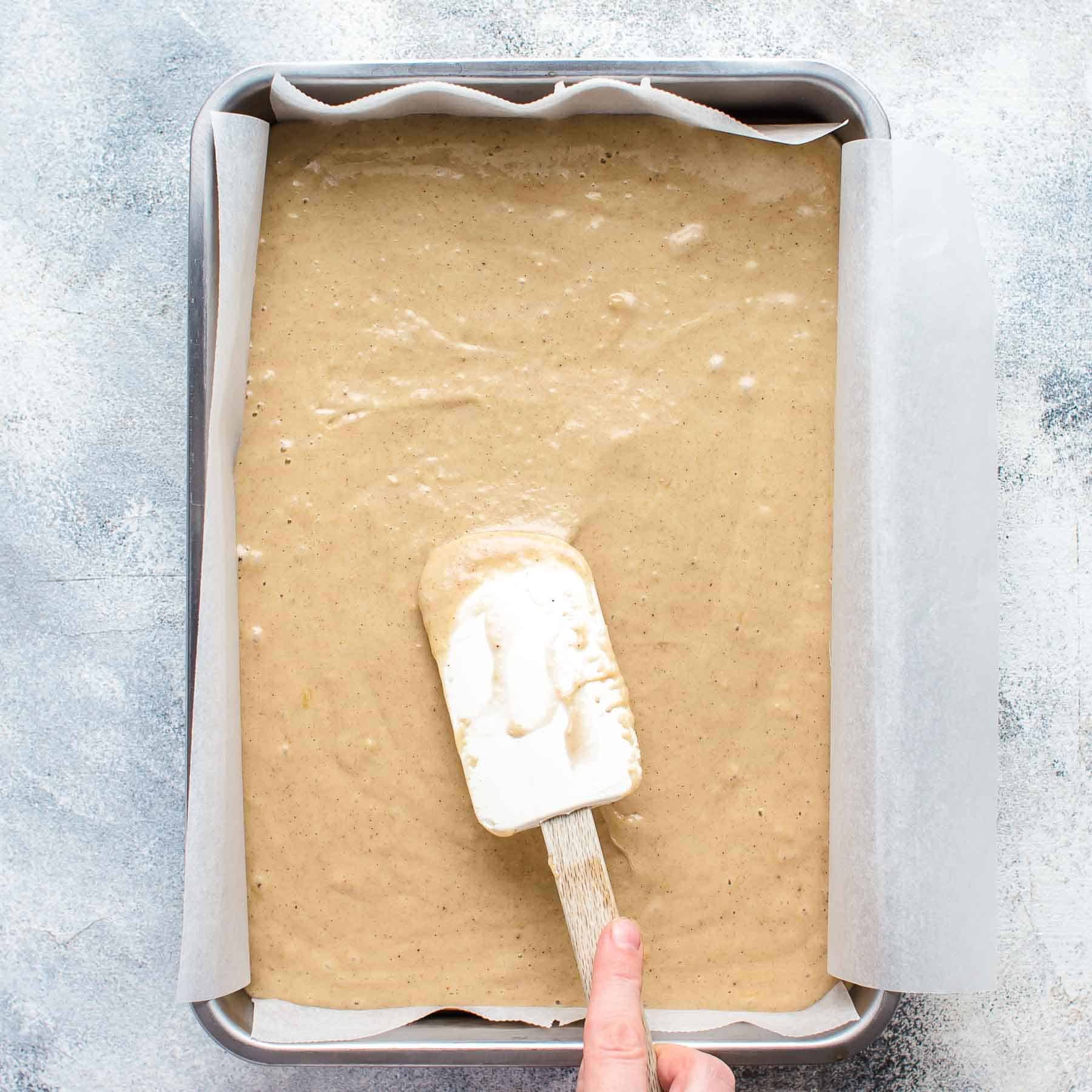 leveling banana cake batter in the baking pan with a spatula
