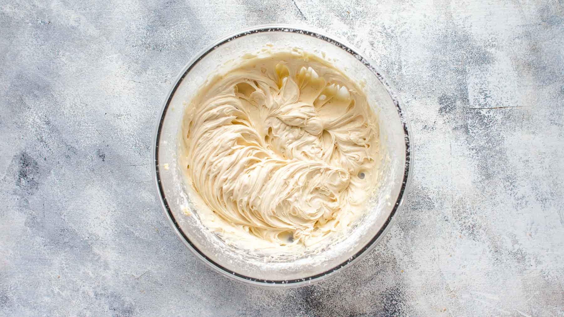 Mixed cream cheese frosting in mixing bowl