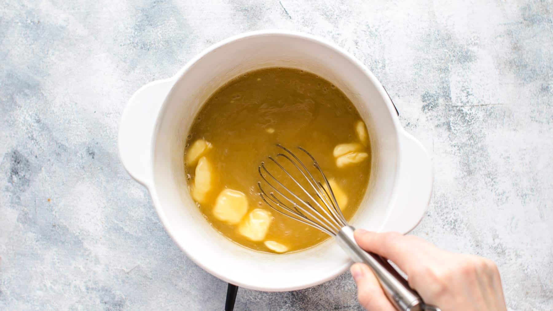 cooking caramel sauce in a white pot