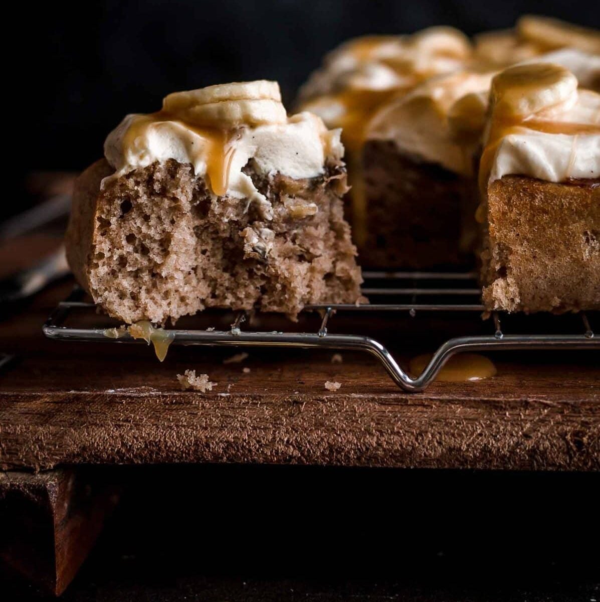 Bitten Banoffee Cake on rack with caramel and banana slices on top